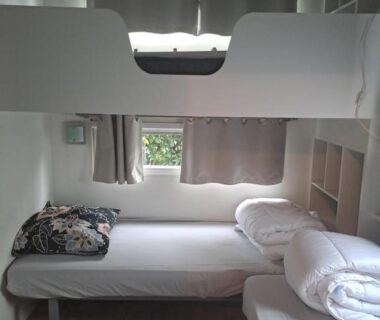 Chambre avec lits superposés et rideaux dans le mobil home Confort Landes 38m2