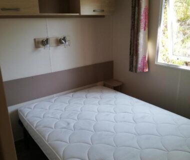 Chambre avec lit et fenêtre dans le mobil home Gassin