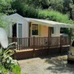 Terrasse en bois et parking ombragé sous les arbres du mobil home Gassin