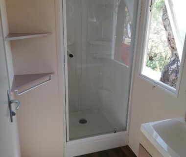 Salle d'eau avec cabine de douche et fenêtre dans le mobil home Gassin