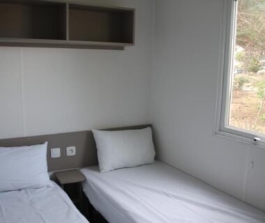 Chambre avec deux lits simples dans le mobil home au lac des rêves