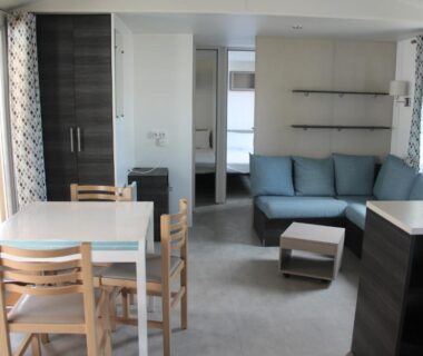 Séjour avec canapé et coin repas dans le mobil home au lac des rêves