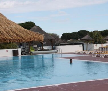 Piscine extérieure avec parasols et transats du mobil home au lac des rêves