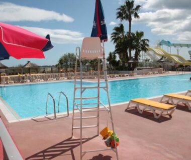 Bord de piscine avec chaises longues et toboggans au mobil home au lac des rêves