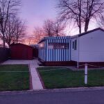 Emplacement herbeux avec mobil home au crépuscule au mobil home camping *** les ollivaud