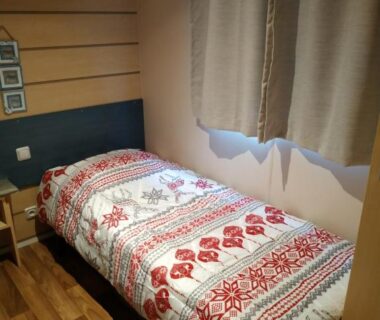 Chambre avec lit simple et parquet dans le mobil home chez ANIK et ALAIN