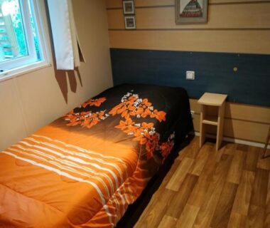 Chambre avec lit simple et fenêtre dans le mobil home chez ANIK et ALAIN