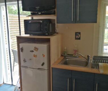 Intérieur kitchenette avec réfrigérateur micro-ondes et évier dans le mobil home chez ANIK et ALAIN