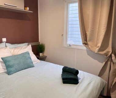 Chambre avec lit double et serviettes dans le mobil home Chill House La Jasse