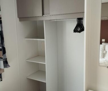 Chambre avec placard ouvert et cintres dans le mobil home chill house la jasse