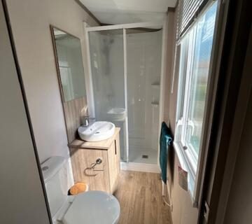 Salle de bain avec cabine de douche et toilettes du mobil home climatisé