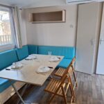 Intérieur coin repas avec banquette et table du mobil home confort 3 chambre