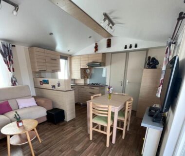 Séjour avec coin cuisine et table à manger dans le mobil home de luxe