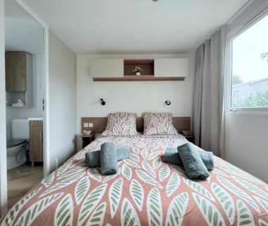 Chambre avec lit double et serviettes dans le mobil home détente et soleil