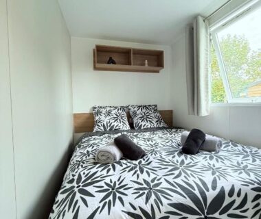 Chambre avec lit double et serviettes dans le mobil home détente et soleil