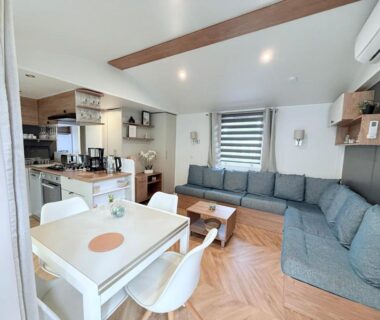 Séjour avec coin repas cuisine équipée et canapé du mobil home détente et soleil