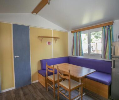 Coin repas avec banquette et table dans le mobil-home du lac de Foix