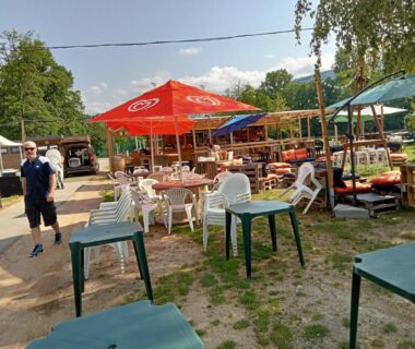 Espace repas extérieur avec parasols et chaises au mobil-home du lac de Foix