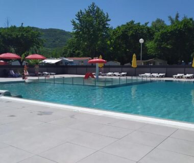 Piscine extérieure avec transats et parasols au mobil-home du lac de Foix