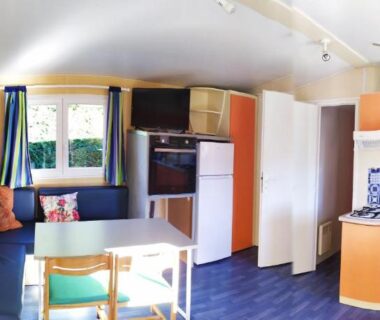 Intérieur avec kitchenette banquette et table dans le mobil-home du lac de Foix
