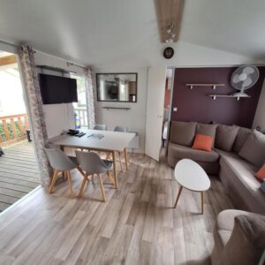 Séjour intérieur avec coin repas et canapé dans le mobil-home Family 6 personnes au Camping Bois Dormant Vendée