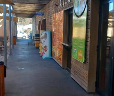 Allée couverte avec boutiques et panneaux au camping Mobil home Le Castellas Bertrand