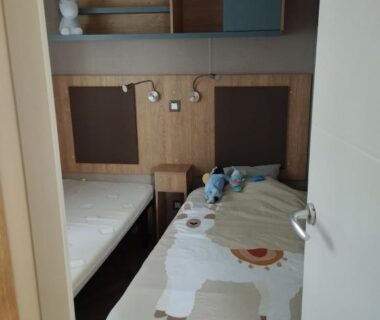 Chambre avec deux lits et rangements dans le mobil home l'écrin bleu bougainvilliers