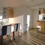 Séjour avec coin repas et cuisine dans le mobil home moderne et spacieux