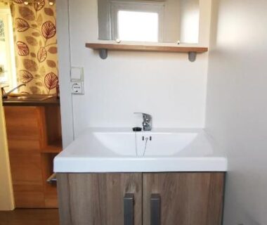 Salle de bains avec lavabo miroir et meuble dans le mobil home moderne et spacieux