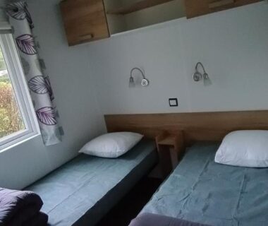 Chambre avec deux lits simples dans le mobil home moderne et spacieux