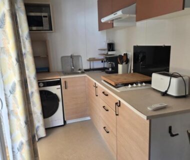 Cuisine équipée avec plaques grille-pain et lave-linge dans le mobil home soleil et detente