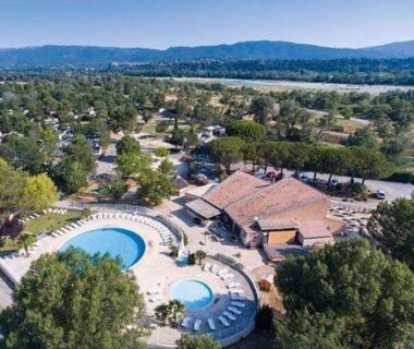Au pied du Luberon piscine circulaire et solarium entourés d'arbres près du mobil home tout confort 6 personnes climatisé