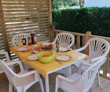 Terrasse couverte avec table dressée et six chaises du mobil home tout confort 6 personnes climatisé au pied du Luberon