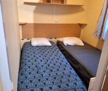 Chambre avec deux lits simples et étagères dans le mobile home 6 personnes-3 chambres