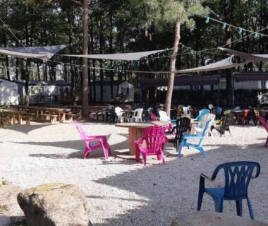 Espace extérieur ombragé avec chaises colorées et tables du mobile home 6 personnes-3 chambres