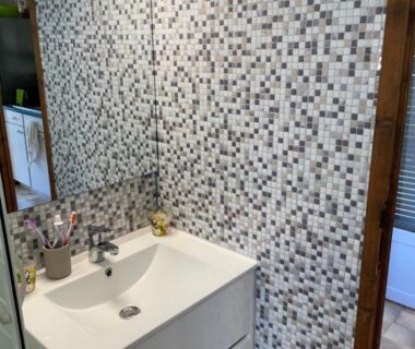 Salle de bains avec lavabo et mur en mosaïque dans le mobile home dans un coin de paradis