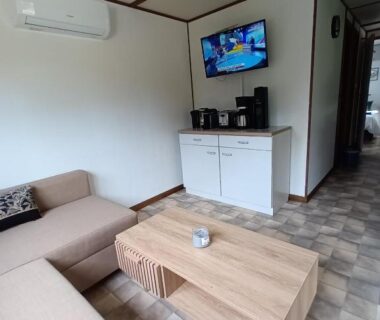 Salon avec canapé et télévision du mobile home dans un coin de paradis