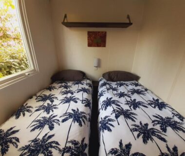 Chambre avec lits jumeaux et fenêtre dans le mobile home entierement équipé