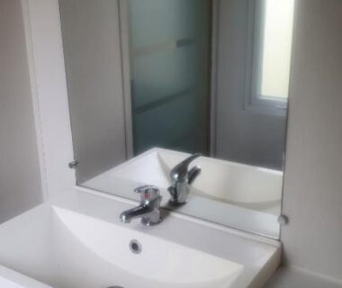 Salle de bains avec lavabo et cabine de douche dans le mobile home entièrement équipé