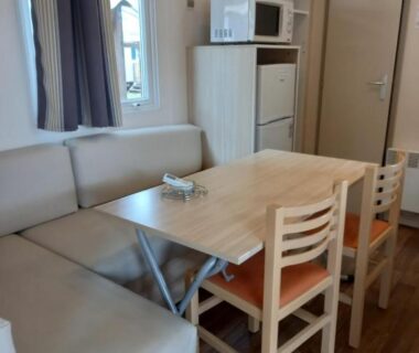 Coin repas avec banquette et kitchenette dans le mobilhome 232 tohapi marvilla