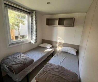 Chambre avec deux lits simples et fenêtre dans le mobilhome 6 couchages grand confort Cap Ferret RM05