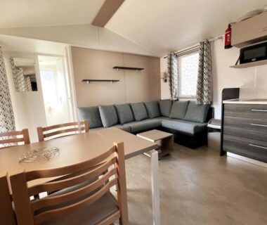 Intérieur salon avec canapé d'angle et coin repas du mobilhome 6 couchages grand confort Cap Ferret RM05