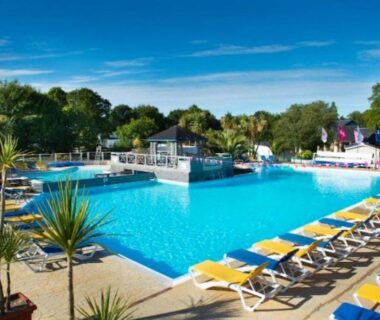 Piscine extérieure avec transats au mobilhome Pont Aven 3chbres 152 avec grande terrasse fermée