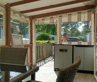 Terrasse couverte avec coin repas et jardinet du mobilhome Pont Aven 3chbres 152 avec grande terrasse fermée