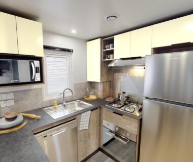 Cuisine équipée avec réfrigérateur micro-ondes évier et plaque de cuisson dans le mobilhome neuf