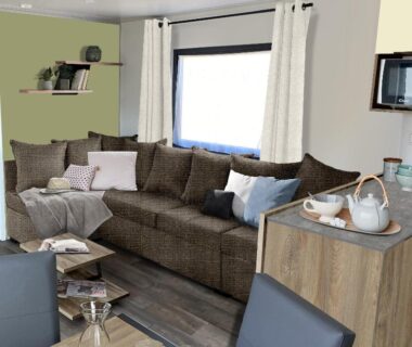 Intérieur salon avec canapé et coin repas dans le mobilhome neuf
