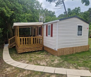 Terrasse en bois et allée dans les pins du mobil'home tout confort