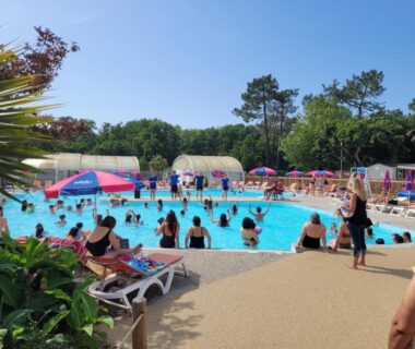 Piscine extérieure avec baigneurs et parasols au mobil’home tout confort