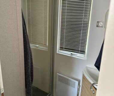 Salle d'eau avec miroir placard coulissant et fenêtre dans le mobilhomme 3 Chambres avec piscine