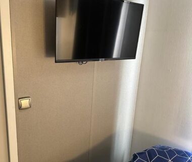 Chambre avec télévision murale et lit dans le mobilhomme 3 Chambres avec piscine
